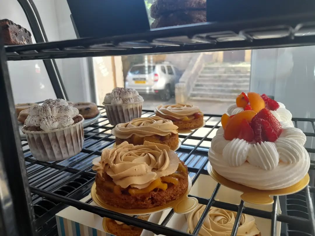 Vitrine réfrigérée garnie de pâtisseries artisanales : tartes, entremets à la crème et fruits frais